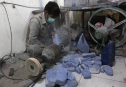 FILE - An Afghan man works at a lapis lazuli factory in Kabul.
