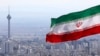 FILE - In this March 31, 2020, file photo, Iran's national flag waves as Milad telecommunications tower and buildings are seen in Tehran, Iran. 