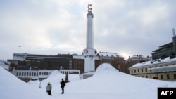 Ljudi stoje u snijegu u glavnom gradu Finske, Helsinkiju, 3. januara 2024. godine.