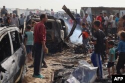 Palestinci se okupljaju na mestu izraelskog udara na kamp za interno raseljena lica, u Rafi, 27. maja 2024.