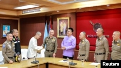 Chinese actor Wang Xing shakes hands with a Thai police officer after being returned to Thailand Jan. 7, 2025. He had been kidnapped and forced to work in a telecom fraud center in Myanmar. Royal Thai Police/Handout via REUTERS