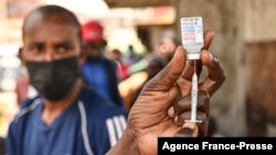 FILE - A health official prepares the Moderna COVID-19 vaccine during a mass Covid-19 vaccination drive in Nairobi, Kenya, Sept. 17, 2021.