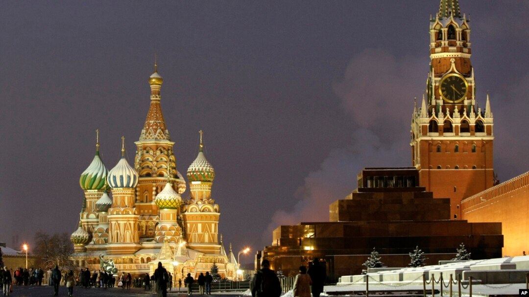 FILE - People walk in Red Square, with St. Basil Cathedral (left) the Kremlin's Spassky Tower (right rear) and Lenin Mausoleum (right) in Moscow, Dec. 10, 2009.