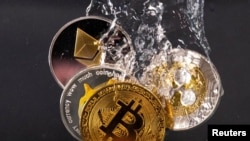 FILE PHOTO: Souvenir tokens representing cryptocurrency networks Bitcoin, Ethereum, Dogecoin and Ripple plunge into water