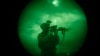 FILE - A US soldier patrols at night in Khost province, Afghanistan, seen through night vision equipment in this 2008 file photo.