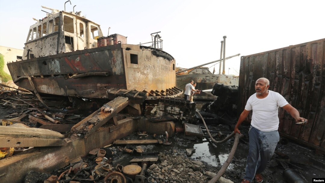 Workers inspect damage at the site of an air strike on the maintenance hub at the Hodeida port, Yemen, May 27, 2018. 