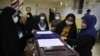 Election officials open a ballot box for the presidential elections at a polling station in Tehran, Iran, early on June 19, 2021. Iranians voted Friday in a presidential election dominated by Supreme Leader Ayatollah Ali Khamenei's hard-line protege.