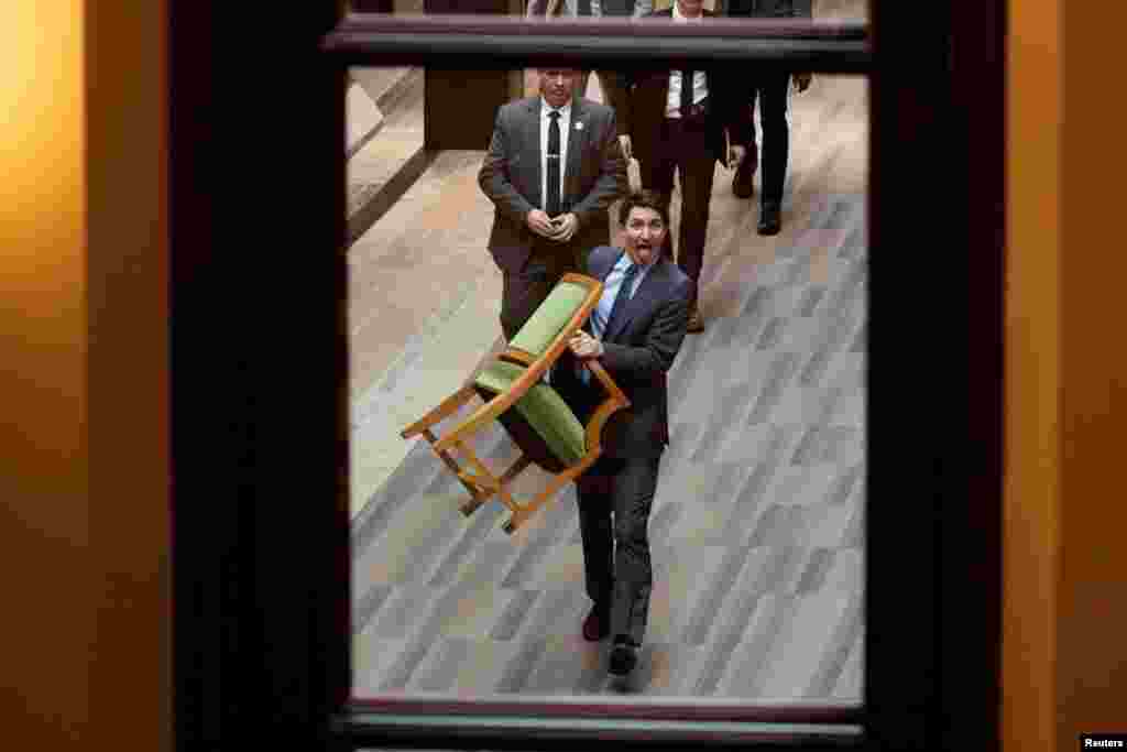 Canada's Prime Minister Justin Trudeau carries his chair from the House of Commons on Parliament Hill in Ottawa, Ontario, March 10, 2025.