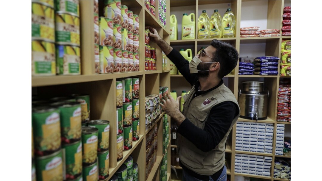 FILE - A volunteer with the Lebanese NGO Beit al-Braka organizes food to be distributed to the needy, at the group's headquarters in the capital Beirut, February 23, 2021.