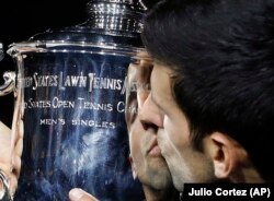 Novak Đoković ljubi trofej namenjen šampionu Ju Es Opena posle pobede nad Huanom Martinom del Potrom u Njujorku (Foto: AP/Julio Cortez)