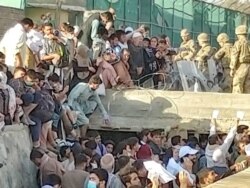 Petugas keamanan membantu evakuasi orang-orang yang menunggu di luar bandara di Kabul, Afghanistan 25 Agustus 2021 (Twitter/DAVID_MARTINON via REUTERS)