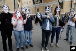Arhiva - Ljudi nose maske sa likom Velikog brata iz novele Džordža Orvela 1984. tokom mitinga podrške većim medijskim sloboddama u Sankt Peterburgu, Rusija, 16. jula 2017.