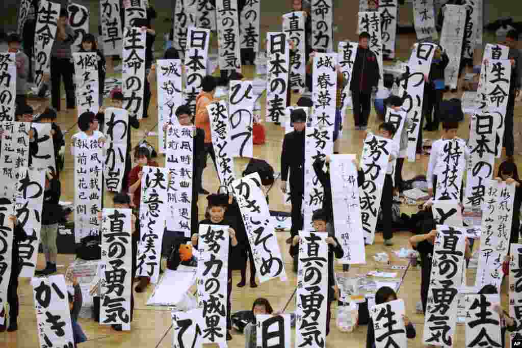 Participants show off their traditional Japanese calligraphy works during the annual New Year's calligraphy contest at the Budokan martial arts hall in Tokyo, Japan, Jan. 5, 2017.