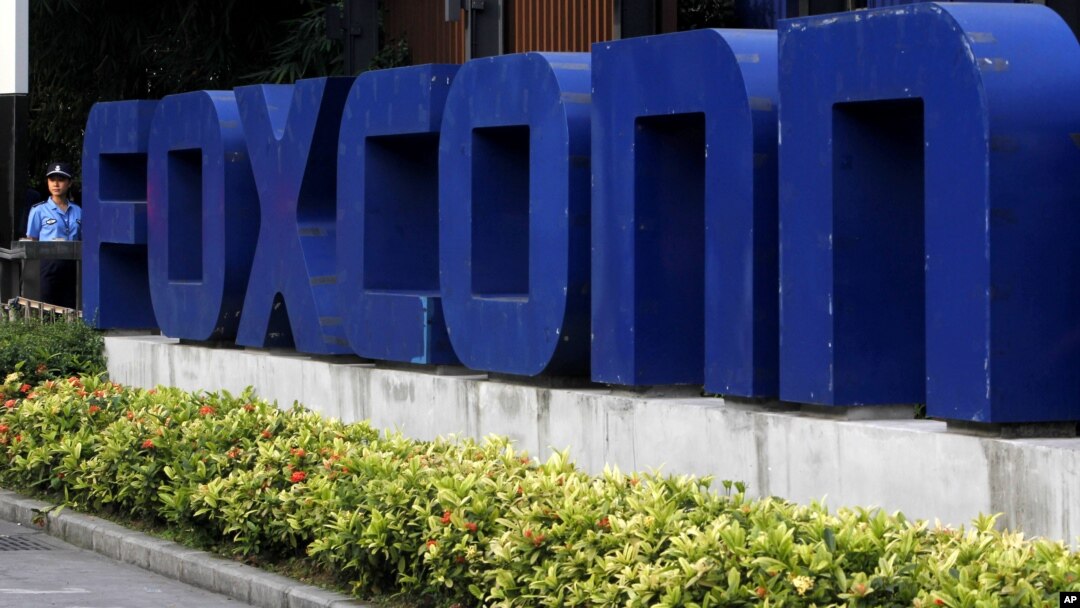 FILE - A security guard stands at the entrance of the Foxconn complex in the southern Chinese city of Shenzhen.