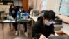 FILE - Students navigate an online lesson with the help of an instructor, at West Brooklyn Community High School in New York City, Oct. 29, 2020. 