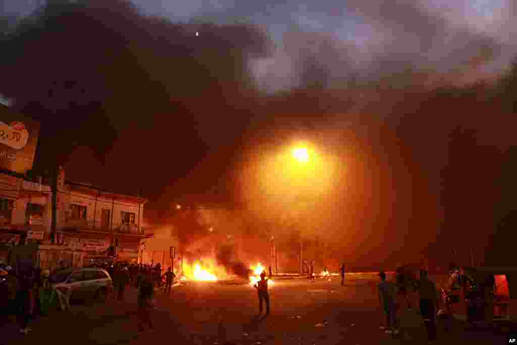 Anti-government protests set fire while security forces fired live ammunition and tear gas near the state-run TV in Baghdad, Iraq.