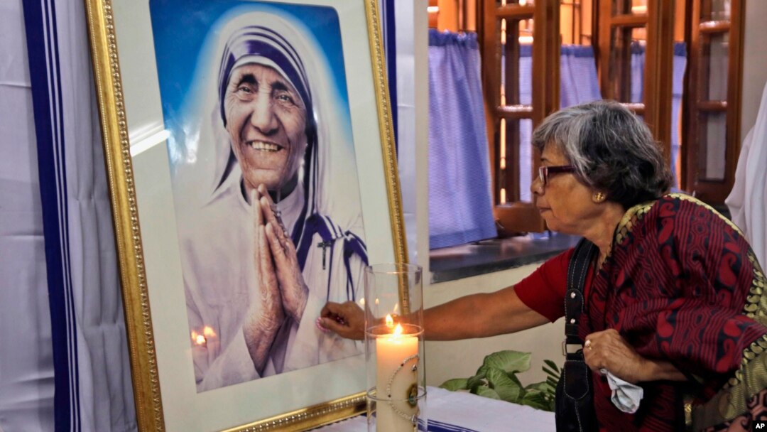 An Indian Catholic woman offers prayers as she touches a portrait of Mother Teresa on her 17th death anniversary at the Missionaries of Charity in Kolkata, India, Sept. 5, 2014.