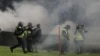 Polisi anti huru hara menembakkan gas air mata saat kerusuhan usai pertandingan sepak bola antara Arema vs Persebaya di Stadion Kanjuruhan, Malang, Jawa Timur, 2 Oktober 2022. (Foto: Antara via Reuters)