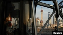 FILE - A bus moves past a bridge with the backdrop of the financial district of Pudong in Shanghai, China, Sept. 27, 2024