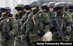 Russian servicemen walk in formation near a Ukrainian military base in Perevalnoye outside Simferopol, Crimea, Ukraine, March 6, 2014.