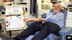 FILE - James Harrison, yang berjasa menyelamatkan 2,4 juta bayi melalui sumbangan plasma darahnya yang memecahkan rekor selama beberapa dekade, sedang mendonorkan darahnya di pusat donor di Sydney, Mei 2011. (Australian Red Cross Lifeblood via AP)