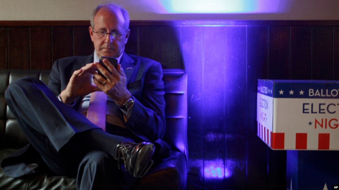 Mark Gilbert, U.S. ambassador to New Zealand, checks election results on his phone in Wellington, New Zealand, Nov. 9, 2016. Gilbert was appointed by President Barack Obama and has been told by the Trump transition team to be out by Jan. 20.
