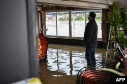 A restaurant owner stands in his flooded restaurant following storm Herminia, in Clecy, northwestern France on Jan. 27, 2025.