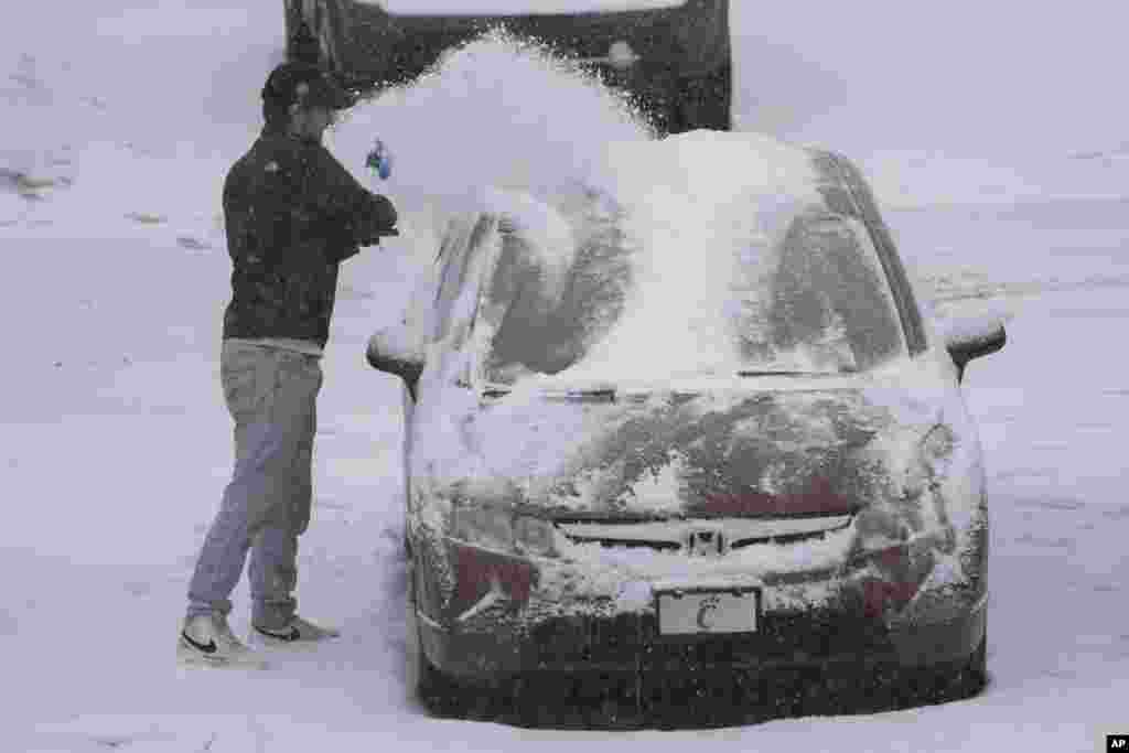 Uma pessoa tira a neve de um carro durante uma tempestade de inverno, a 5 de janeiro de 2025, em Cincinnati, Ohio.