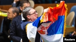 Predsednik Srbije Aleksandar Vučić drži zastavu Srbije u Generalnoj skupštini Ujedinjenih nacija na sednici na kojoj se glasalo o rezoluciji o genocidu u Srebrenici (REUTERS/Eduardo Munoz)