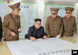 Na ovoj fotografiji, načinjenoj od video snimka emitovanog 14. avgusta 2017. u biltenu vesti, vidi se severnokorejski lider Kim DŽong Un kako prima izveštaje svojih oficira u Pjongjangu, Severna Koreja.