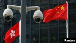 資料照：在香港政府總部大樓外監視攝影機後的中國國旗和香港特區旗幟。