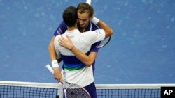 Zagrljaj Danila Medvedevi Novaka Đokovića na mreži posle finala US Opena (Foto: AP)