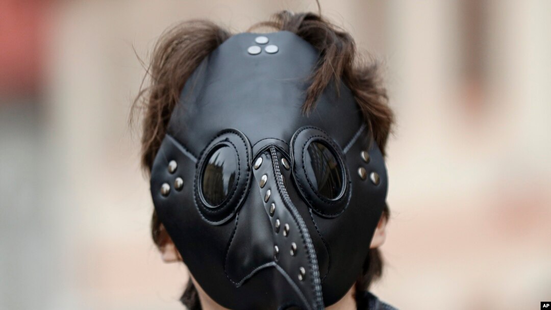 A man wears a mask as demonstrators gather to protest the COVID-19 preventative measures downtown Prague, Czech Republic. (AP Photo/Petr David Josek)