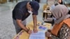 FILE - A Libyan man registers to vote inside a polling station in Tripoli, Nov. 8, 2021. 