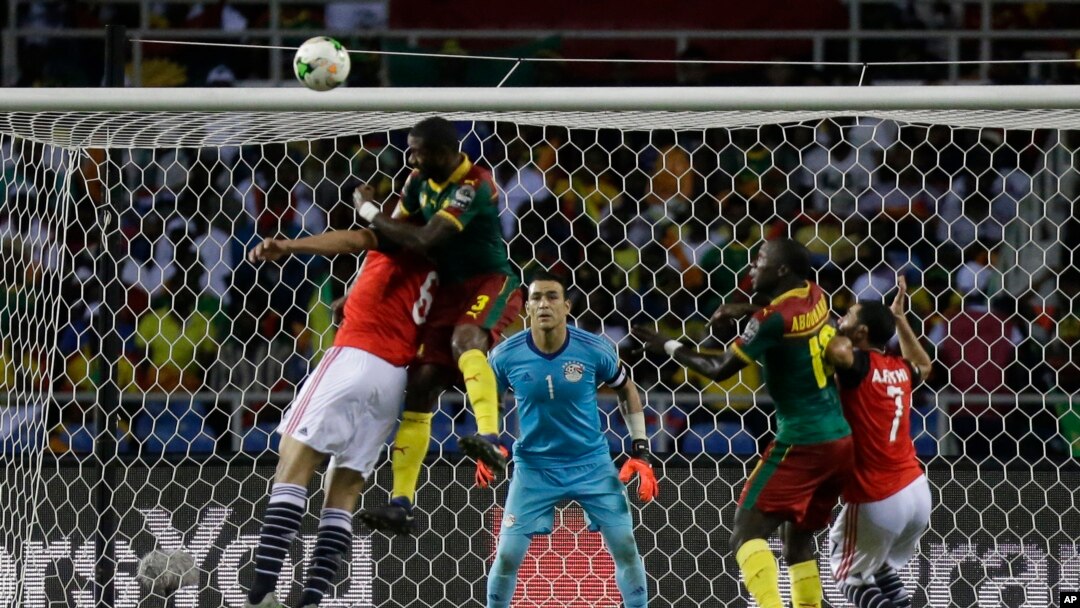 Egypt goalkeeper Essam El Hadary, center, watches as Cameroon's Nicolas Nkoulou, 2nd left, jumps to score his side's first goal during the African Cup of Nations final soccer match between Egypt and Cameroon at the Stade de l'Amitie, in Libreville, Gabon,