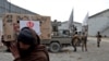 FILE - An Afghan man carries a package distributed by a Turkish humanitarian aid group at a distribution center in Kabul, Afghanistan, Dec. 15, 2021. 