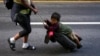FILE - Nayely Nunez, from Honduras, uses her luggage to carry a child as she walks along the highway with a migrant caravan in Huixtla, southern Mexico, heading toward the country's northern border and ultimately the United States, Nov. 7, 2024.