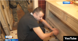 Pogorelov, showing where he allegedly planted a bomb at Pushkin Cafe in a "failed attempt" on Zakharchenko's life in 2017. (Screengrab from "News of the Week with Dmitry Kisleyov, Rossiya 1).