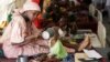 FILE - A mother feeds her malnourished child at a feeding center in Maiduguri, Nigeria, Aug. 29, 2016.