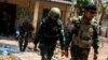 FILE - LT Saw Kaw, seorang prajurit Tentara Pembebasan Nasional Karen (KNLA), berjalan bersama anggota timnya setelah memeriksa rumah seorang pejabat tinggi militer Myanmar di Batalyon Infanteri 275 di Myawaddy, 15 April 2024.