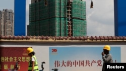 中國工人從雲南省昆明市一處建築工地旁走過。（2019年9月17日）