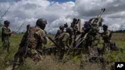 Arhiva - Ukrajinski vojnici pripremaju paljbu na ruske pozicije iz haubice M777, koju su obezbedile SAD - u regionu Harkova, Ukrajina, 14. jula 2023.