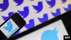 (FILES) In this file photo taken on May 2, 2019 logos of US social network Twitter are displayed on the screen of smartphones, in Nantes, western France. 