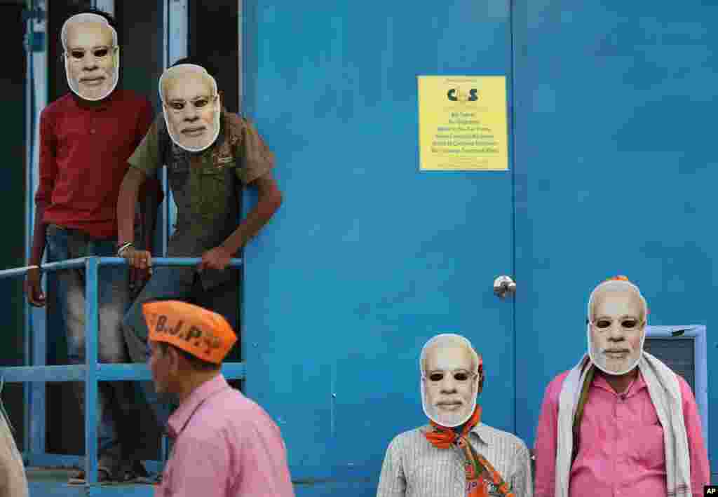 Hindistan'ın Prayagraj kentinde seçim kampanyasına katılan Başbakan ve Bharatiya Janata Partisi'nin lideri Narendra Modi'nin maskesini takan Hintli destekçileri.
