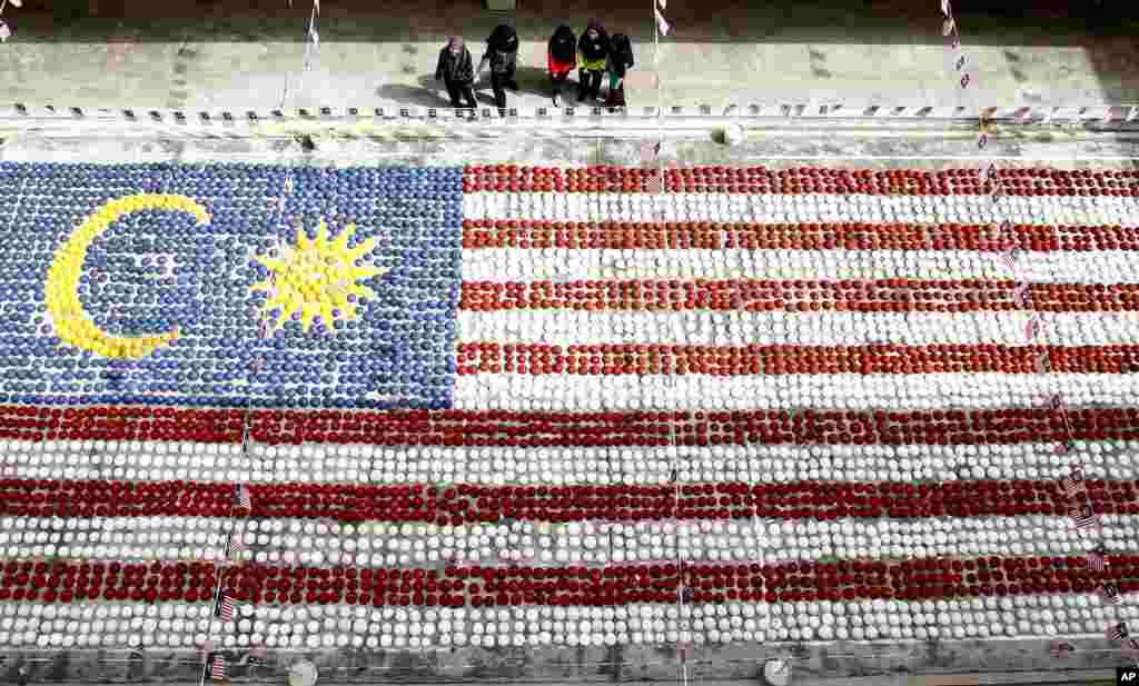 Students watch a giant Malaysian national flag made of coconut shells at Selayang in Kuala Lumpur.