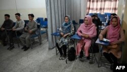 Students attend a class bifurcated by a curtain separating males and females at a private university in Kabul, Afghanistan, Sept. 7, 2021, to follow the Taliban's ruling.