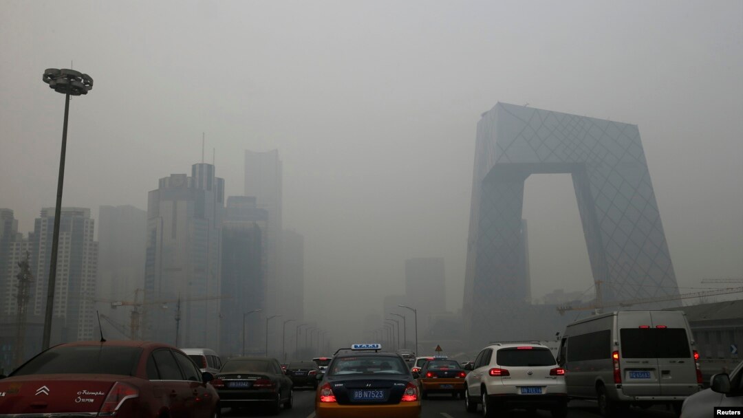 FILE - Cars travel on a road amid heavy haze in Beijing, Feb. 21, 2014. 