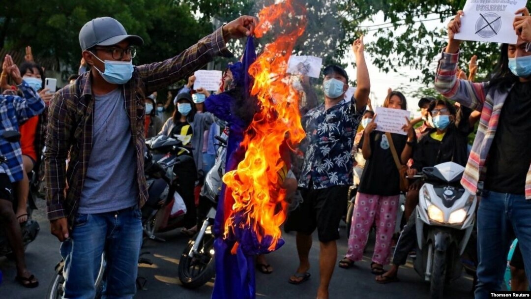 FILE - Protesters against Myanmar's junta burn the flag of the Association of Southeast Asian Nations (ASEAN), in Mandalay.