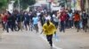 People charge towards the police during a nationwide strike called by Mozambique presidential candidate Venancio Mondlane to protest the provisional results of an Oct. 9 election, in Maputo, Mozambique, Oct. 21, 2024. 