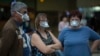 People wearing masks wait for passengers at Johannesburg's O.R. Tambo International Airport, South Africa, March 16, 2020, a day after President Cyril Ramaphosa declared a national state of disaster.